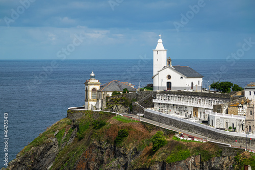 Picturesque chapel with cementery and a lighthouse overlooking Cantabrian sea in the village of Luarca, Asturias, Spain. photo