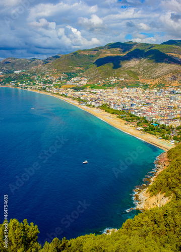 sunny view of Alanya and the port against the backdrop of mountains and clouds in autumn