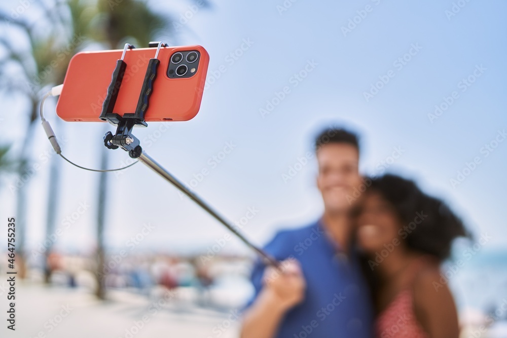 Man and woman couple hugging each other make selfie by the smartphone at seaside