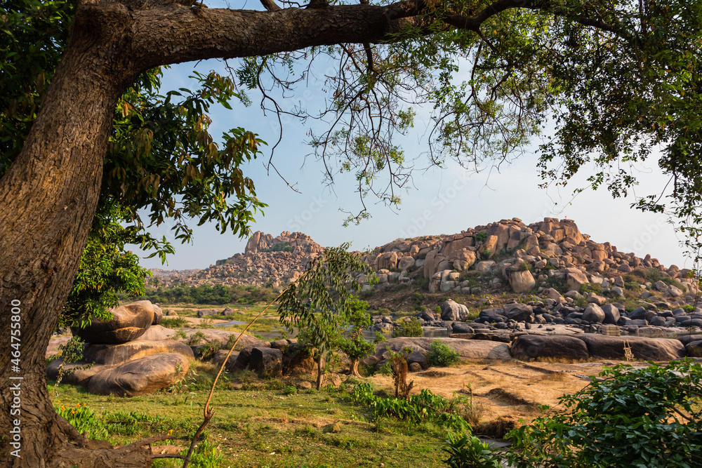 Obraz premium インド ハンピのトゥンガバドラ川沿いの風景と岩山