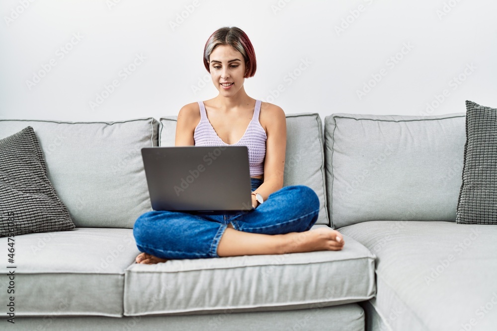 Young caucasian girl using smartphone sitting on the sofa at home. Young caucasian girl using smartphone sitting on the sofa at home.