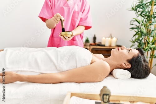 Middle age hispanic woman having aromatic treatment at beauty center