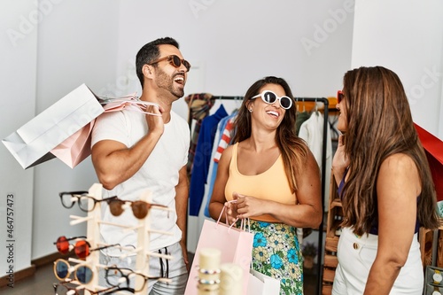 Bild auf Leinwand Group of young hispanic people smiling happy trying on sunglasses at clothes store