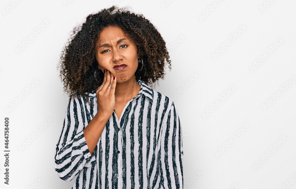 Young african american girl wearing casual clothes touching mouth with hand with painful expression because of toothache or dental illness on teeth. dentist
