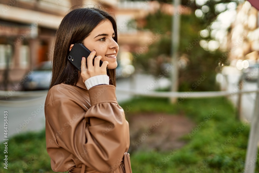 Young beautiful brunette woman smiling happy outdoors speaking on the phone