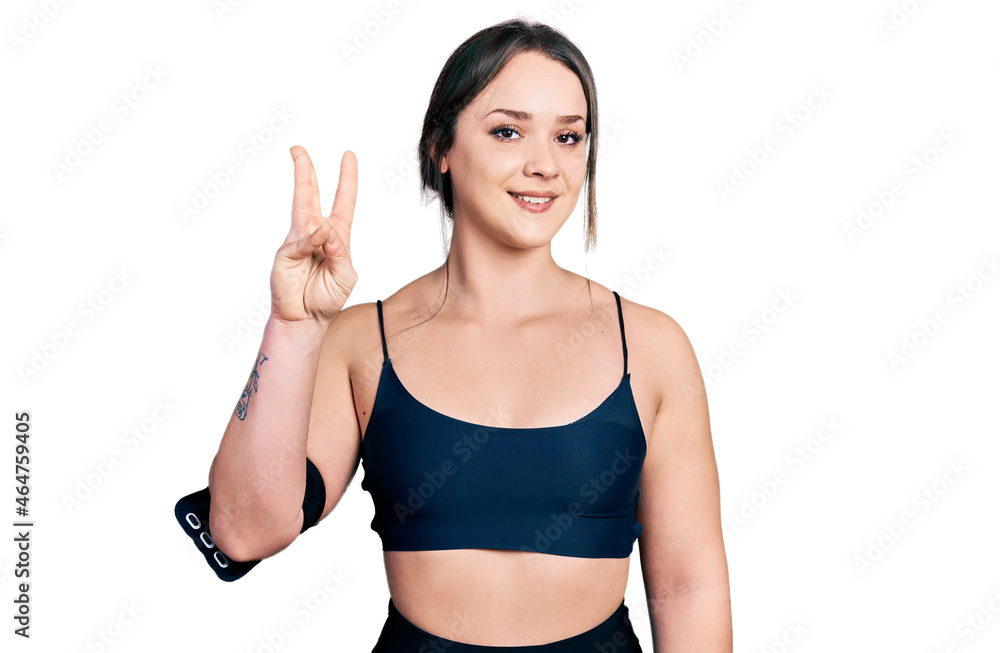 Young hispanic woman wearing sportswear showing and pointing up with fingers number three while smiling confident and happy. Young hispanic woman wearing sportswear showing and pointing up with fingers number three while smiling confident and happy.