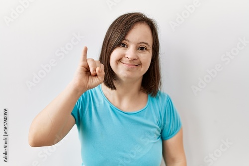 Wallpaper Mural Young down syndrome woman standing over isolated background showing and pointing up with finger number one while smiling confident and happy. Torontodigital.ca