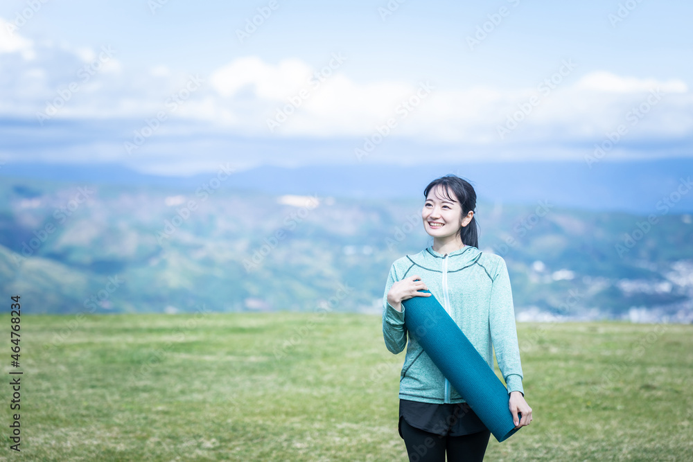 ヨガマットを持つ女性
