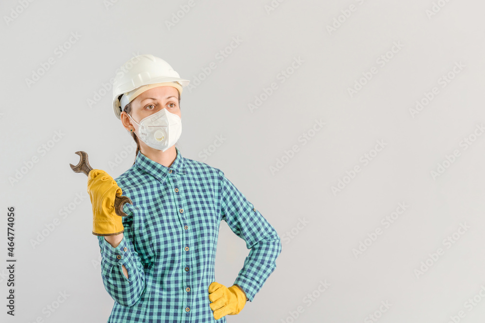 A female car mechanic holds a rusty гаечный ключ in front of her at arm's length. Selective focus, copyspace A female car mechanic holds a rusty гаечный ключ in front of her at arm's length. Selective focus, copyspace