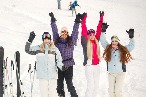 Girls posing against backdrop of mountains in ski gear.