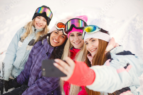 Group of girls taking selfies in mountains on skis