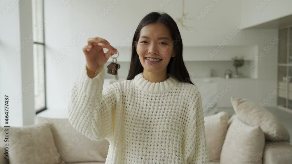 Young Asian woman gets the keys to the house and signs a contract with a real estate agency Young Asian woman gets the keys to the house and signs a contract with a real estate agency