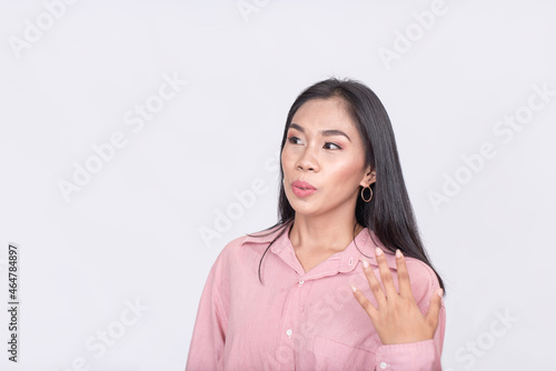 A young woman pleasantly surprised and in awe. Hand on shoulder. Isolated on a white background. photo