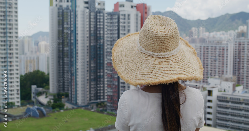 Woman wear straw hat and look at the city of Hong Kong