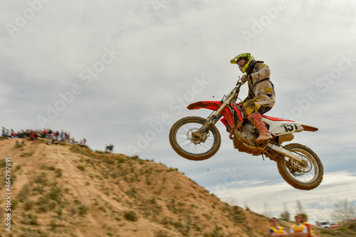 Una imagen de un motociclista haciendo un truco y saltando en el aire. photo