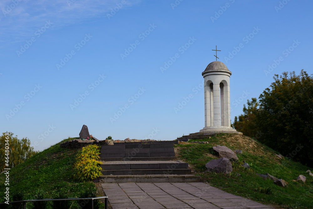 beautiful landscape and a small bell tower. a detail of the building a small bell tower with a cross stands on a hill. faith, religion. space for text. Christianity or Catholicism. autumn time