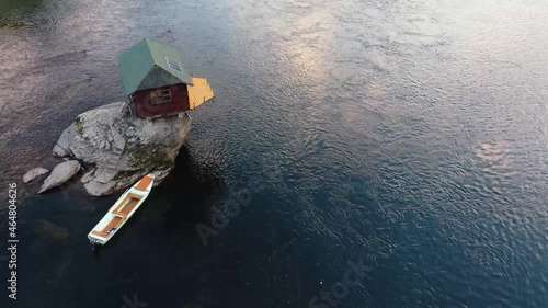 Small wooden cabin on a rock in the middle of river Drina, Serbia.	
