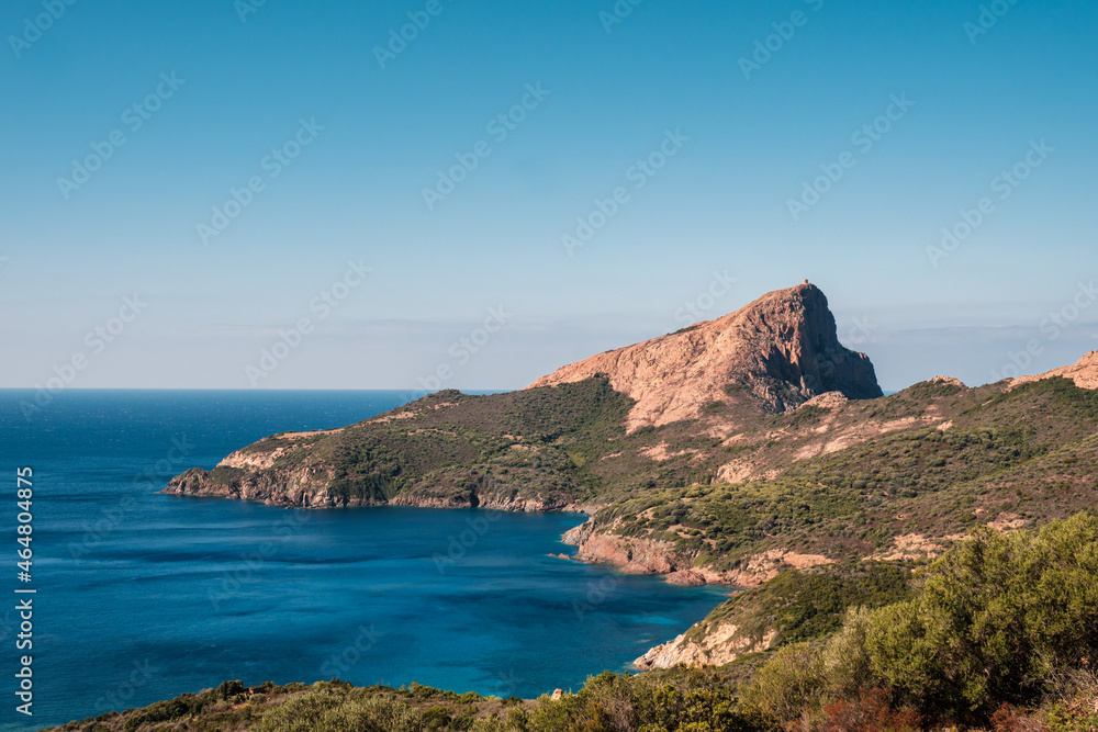 Genoese tower of Tour de Turghiu sitting on Capo Rosso and the rugged west coast of Corsica and the Mediterranean sea