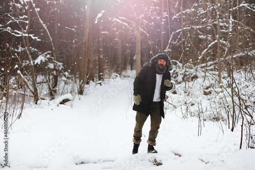 Outdoor portrait of handsome man in coat and scurf. Bearded man in the winter woods.