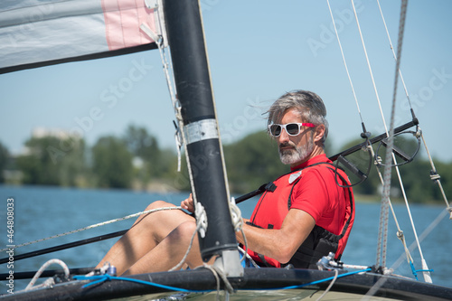 man on his small sailboat