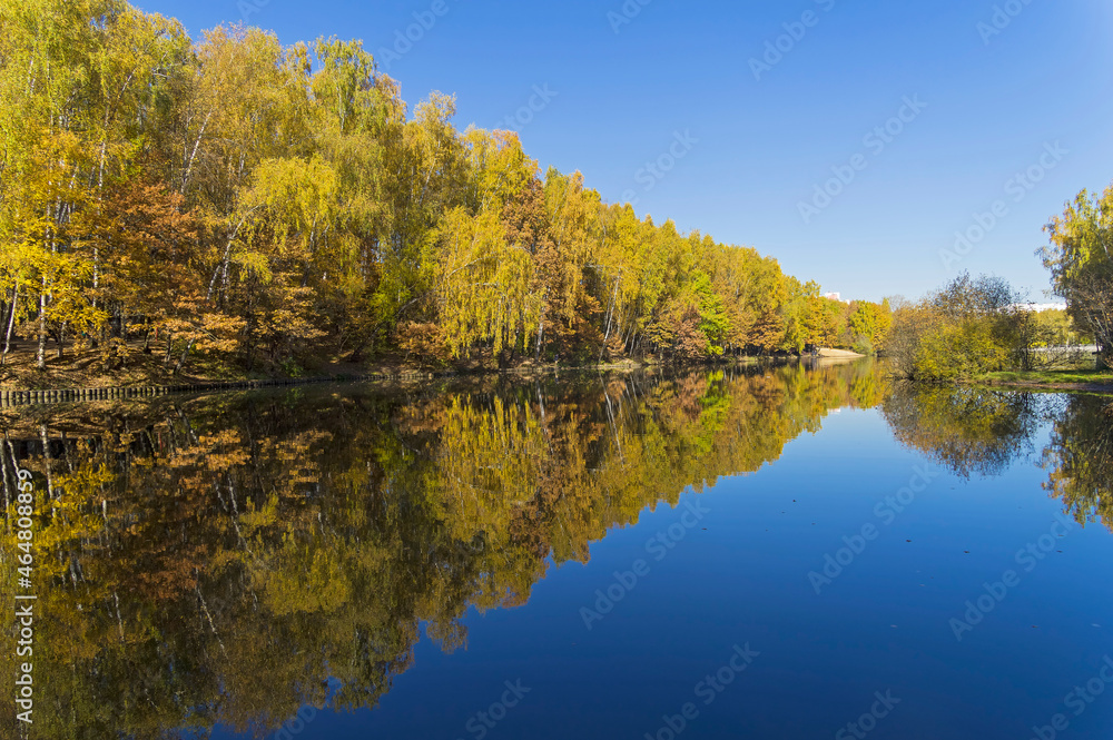 Beautiful mirror reflection of the coastal autumn forest in the pond. Beautiful mirror reflection of the coastal autumn forest in the pond.