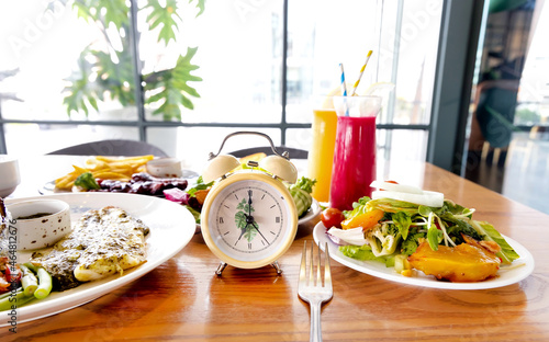  Selective focus of Yellow clock with a healthy food and drink background for a dinnertime with Intermittent fastin concept photo