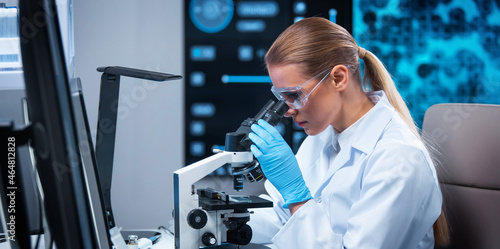 Female doctor works in a modern scientific laboratory using equipment and computer technologies. The scientist does research and develops new vaccines. Science and healthcare concept.