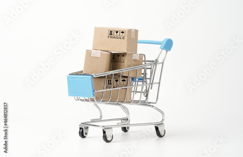 Isolated of shopping cart trolley with paper boxes on white background for online shopping and delivery concept.