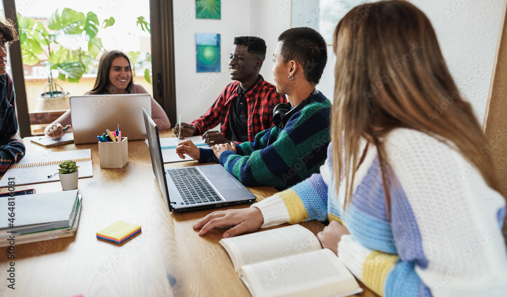 Multiracial students reading books and using laptop while studying together - School concept - Focus on right asian man face Multiracial students reading books and using laptop while studying together - School concept - Focus on right asian man face