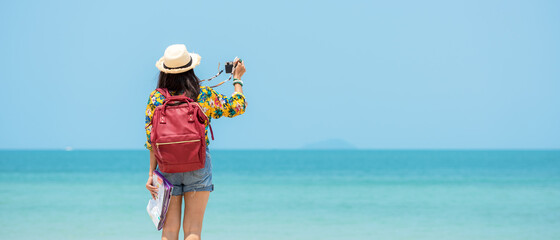 Happy traveler and tourism women travel summer on the beach.  Asia smiling people holding map and camera take photo  and relax outdoor for destination and leisure trip travel in holiday.