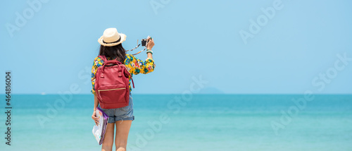 Happy traveler and tourism women travel summer on the beach.  Asia smiling people holding map and camera take photo  and relax outdoor for destination and leisure trip travel in holiday.