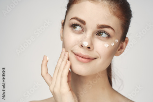 woman with face cream naked shoulders cosmetics face care