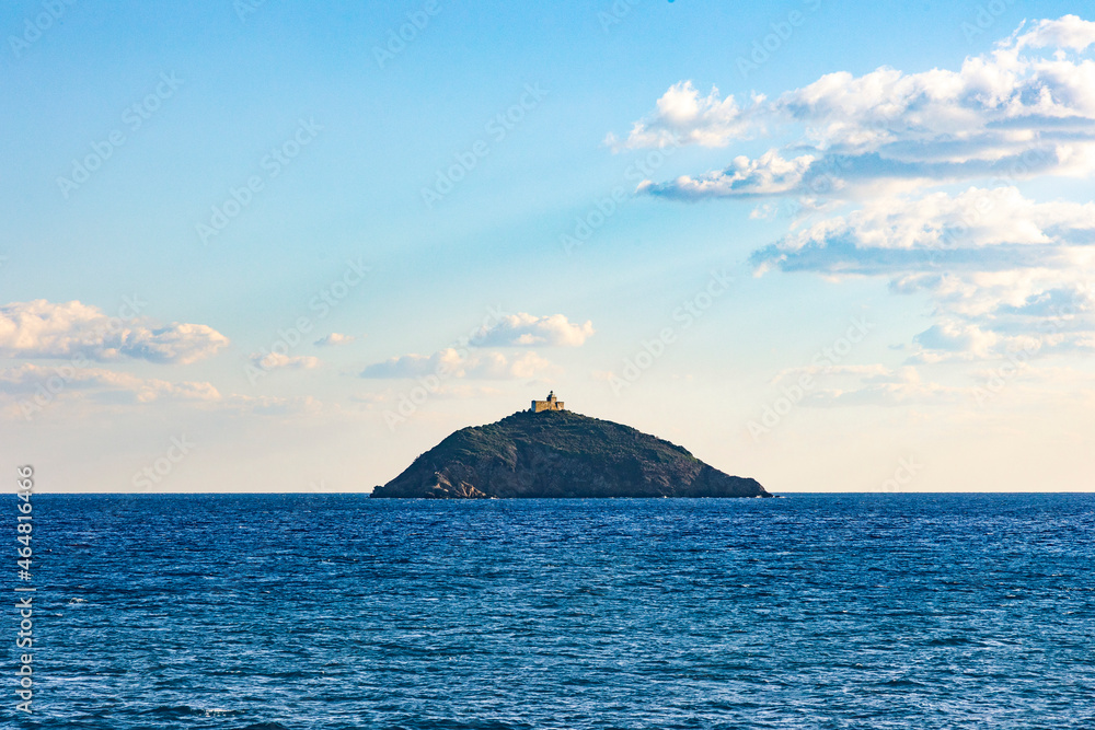 Palmaiola Island in the Mediterranean Sea between Piombino and Elba with lighthouse under blue sky Palmaiola Island in the Mediterranean Sea between Piombino and Elba with lighthouse under blue sky