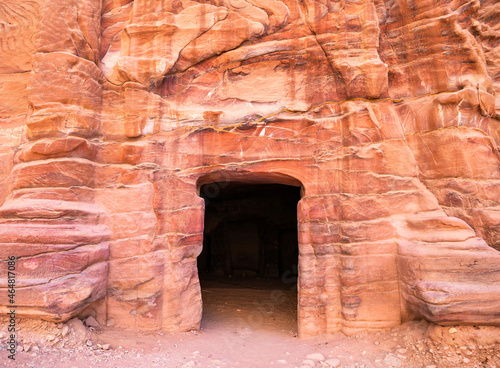 Entrance in a tomb carved in red sand stone located in the ancient city of Petra, Jordan.