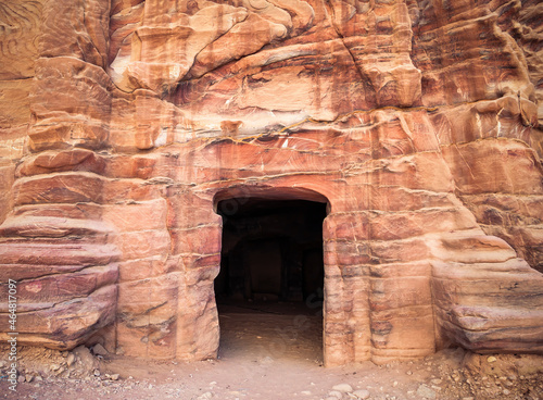 Entrance in a tomb carved in red sand stone located in the ancient city of Petra, Jordan.