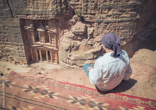 Tourist looking at the The Treasury (Al-Khazneh) from Al-Khubtha Trail Viewpoint, in Petra Jordan.Tourist looking at the The Treasury (Al-Khazneh) from Al-Khubtha Trail Viewpoint, in Petra Jordan.