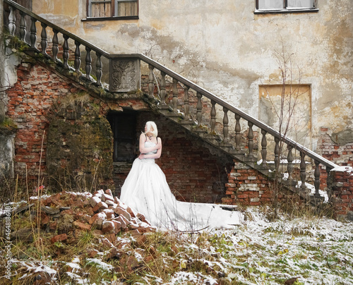 Foto Portrait of  young adult slim caucasian woman stand against abandoned old wall fence