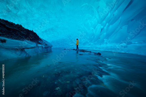 A man stand alone in ice cave at Mandenhall Glacier in Juneau, Alaska photo