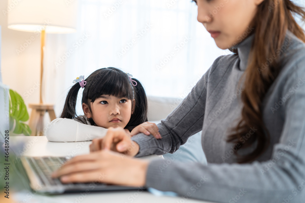 Asian young kid daughter feeling sad and need to play with busy mother. Asian young kid daughter feeling sad and need to play with busy mother.