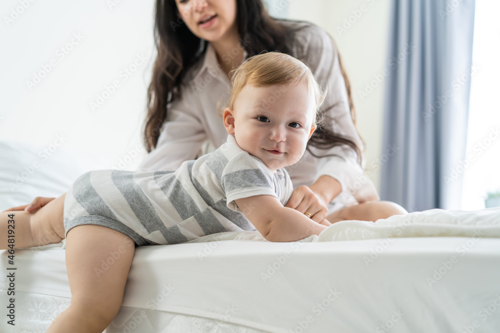 Caucasian loving mom play with cute baby boy child on bed in bedroom
Caucasian loving mom play with cute baby boy child on bed in bedroom