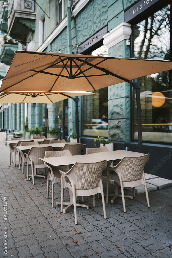 Empty cafes in the town. Summer cafe terrace. Dining tables and chairs in a street cafe