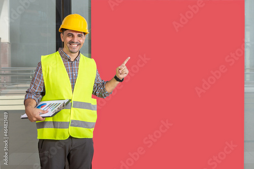 worker smiling and fingering a red banner Fototapeta