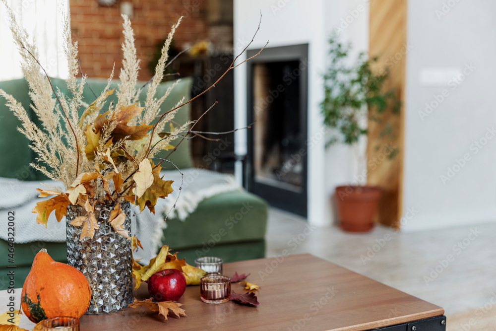 Autumn time home interior. Bouquet in vase on table, pumpkin, apples, leaves Autumn time home interior. Bouquet in vase on table, pumpkin, apples, leaves
