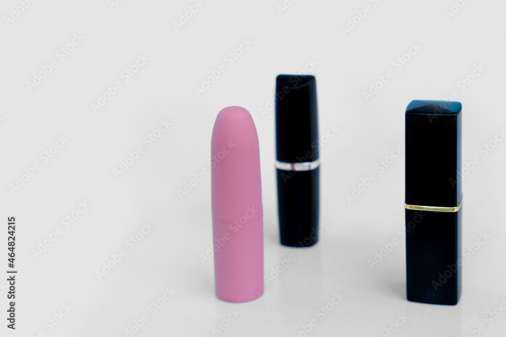set, 3 pieces of lipstick in closed cases on white isolated background, red, raspberry, pink, coral, peach color, close-up, the concept of decorative cosmetics set, 3 pieces of lipstick in closed cases on white isolated background, red, raspberry, pink, coral, peach color, close-up, the concept of decorative cosmetics