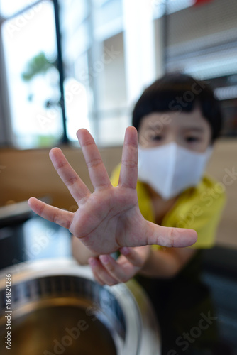 Wallpaper Mural A boy wearing a mask is showing a forbidden sign to prevent others from coming close to him to protect himself from germs. Torontodigital.ca