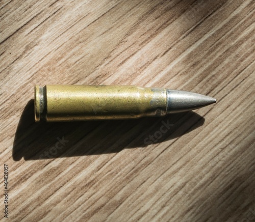 Cartridge, gun bullet on wooden background. Automatic pistol cartridge.