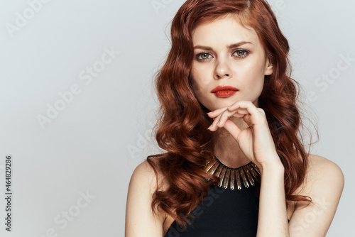 red-haired woman in black dress red lips glamor posing