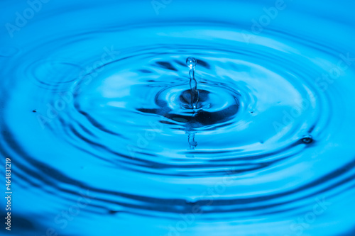 Close up view of drops making circles on water surface isolated on background.