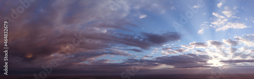 Panorama of dramatic sky at sunrise or sunset. Abstraction of blurred clouds and the sun breaking through the clouds.