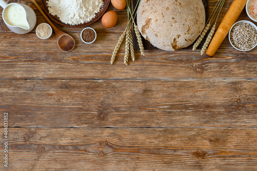 Homemade bread and bakery ingredients on dark rustic wooden background